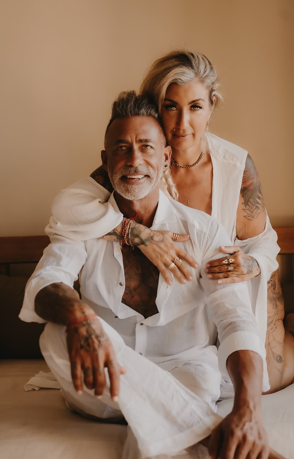 Rex and Rebelle together in white linen, her arm around his shoulders